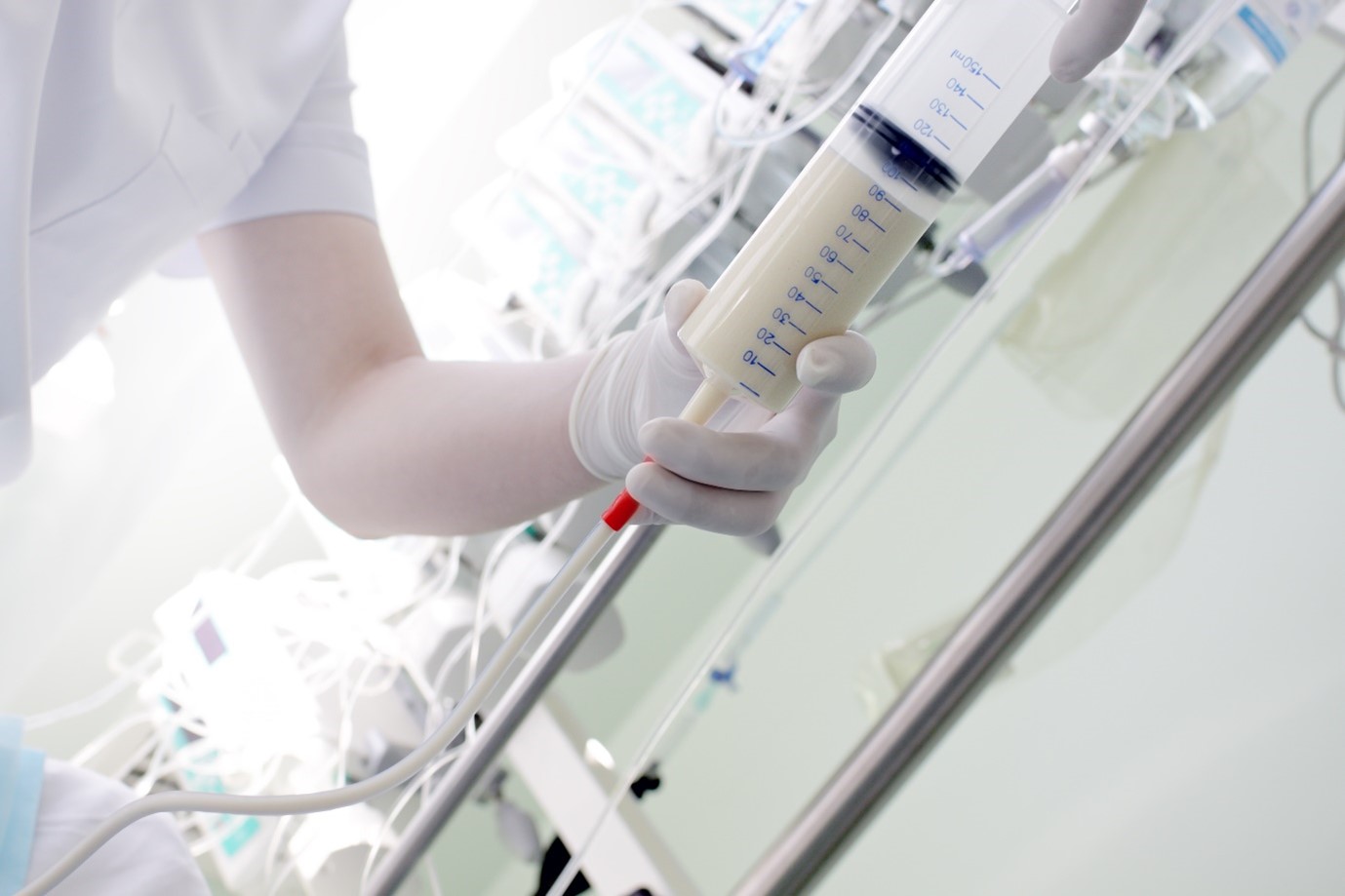 A nurse adjusting a feeding tube