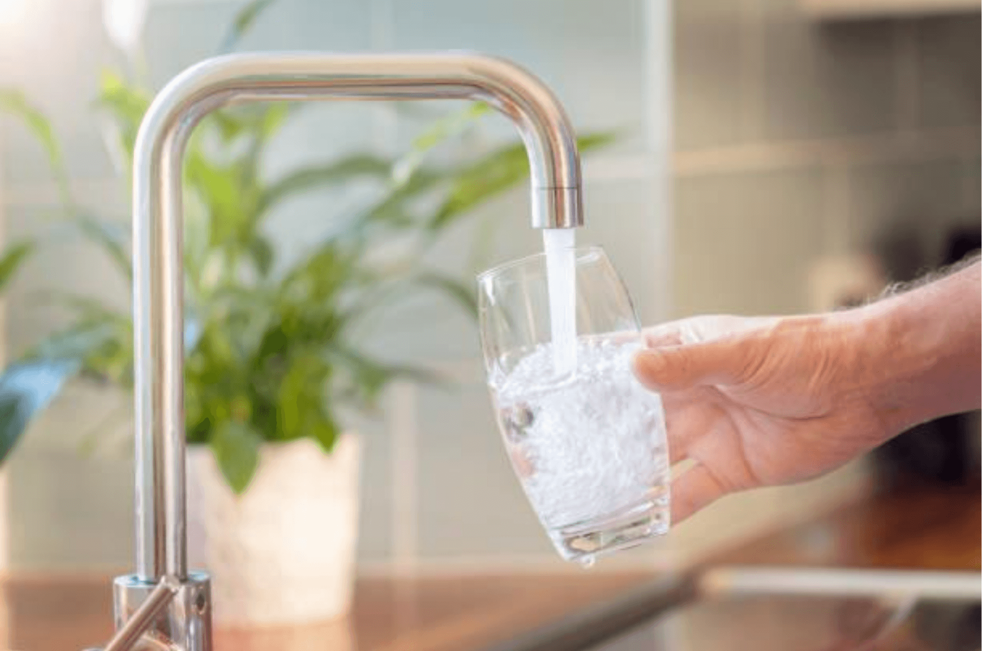 Someone pouring water from a faucet into a glass